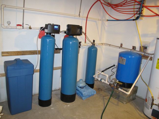 Iron filter and water softener tanks installed in a mechanical room